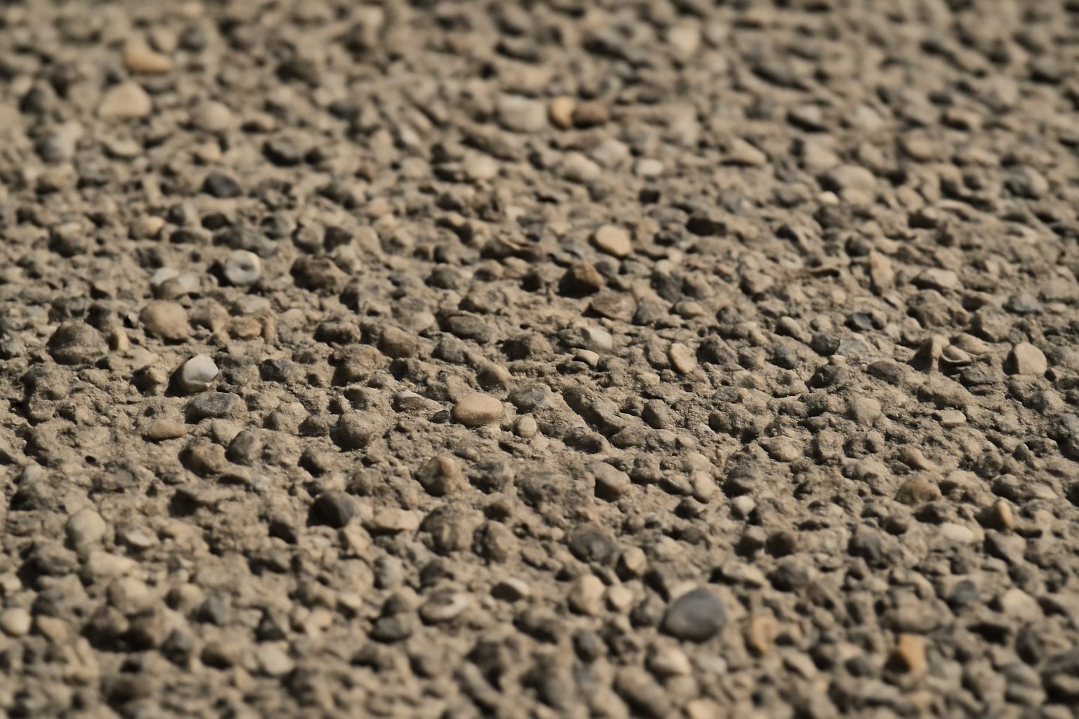 Gros plan sur la texture du béton désactivé révélant les granulats pour une surface drainante et esthétique